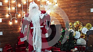 Father Frost Santa Claus rejoices near a fireplace.