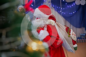 Father Frost speaks with a microphone . Santa Claus is singing Christmas songs against . Man in Santa Claus suit posing