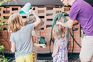 Father gardening at home with three daughter