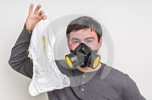 Father with gas mask changing smelly diaper