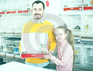 Father with girl acquired the canary and bird cage