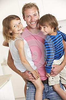 Father Giving Children Cuddle At Home photo