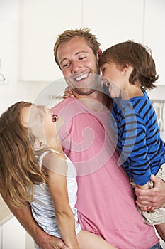 Father Giving Children Cuddle At Home