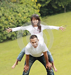 Father giving daughter piggyback ride