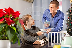 Father giving his teenage son money to celebrate christmas