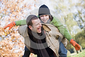 Father giving son piggyback photo