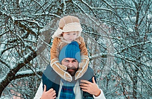 Father giving son ride on back in park. Child sits on the shoulders of his father. Father and son Having Fun in Winter