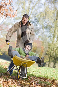 Father giving son ride in wheelbarrow