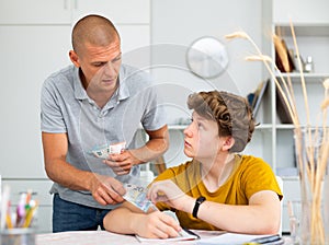 Father giving son money