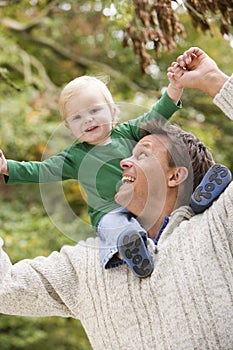 Father giving young son ride on shoulders