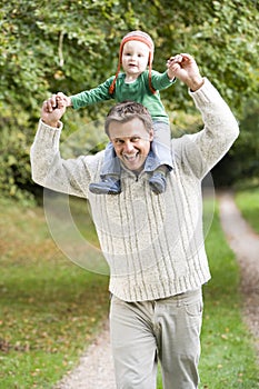 Father giving young son ride on shoulders
