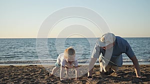 A father goes in for sports with his 5-year-old son on a weekend at the beach