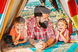 Father have fun with his cute daughter and son. Happy family enjoy being together and play. Young hipster bearded dad