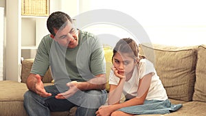 Father having a conversation with daughters at home