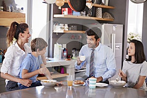 Father Having Family Breakfast In Kitchen Before Leaving For Work