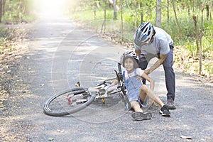 Father helped the daughter fall bike photo