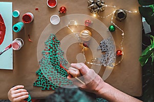 Father helping child making christmas decorations