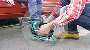 Father helping daughter dresses roller skates closeup