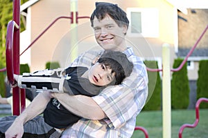 Father helping disabled son to play at playground