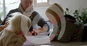 Father helping his children in drawing at home 4k