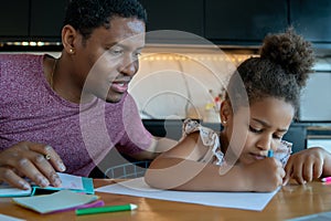 A father helping his daughter with homeschool.
