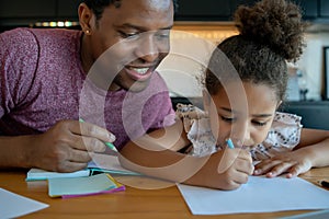 A father helping his daughter with homeschool. photo