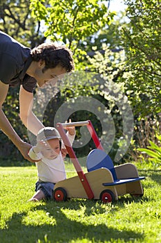 Father helping his son in garden to take his first step of life