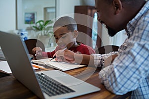 Father helping his son with homework in living room