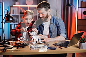 Father helping his son to repairing toy robot dog