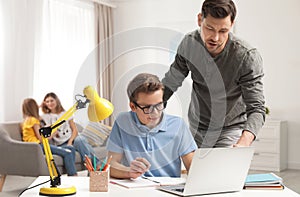 Father helping his teenager son with homework