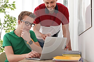 Father helping his teenager son with homework