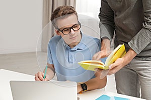 Father helping his teenager son with homework