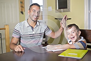 Father helping son do homework. Parent helps his child