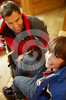 Father Helping Son To Put On Outdoor Clothes