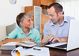 Father helping teenage son with homework