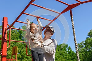 Father helps his child`s daughter to climb the rope. Concept of helping young people