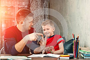 The father helps his son to do homework for the school.