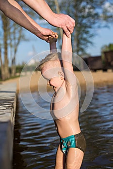 Father helps son to climb on the footbridge