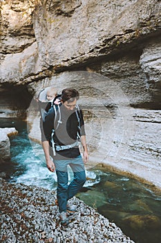 Father hiking in canyon with baby backpack carrier