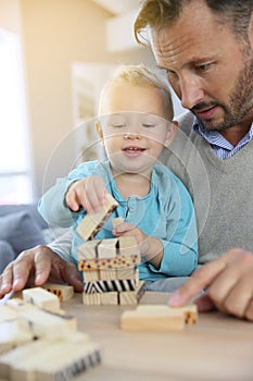 Father and his baby son playing with wooden blocks