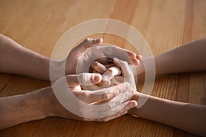 Father with his child praying at wooden table, closeup