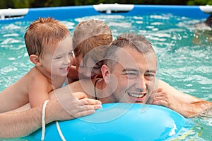 Father and his children having fun in the pool