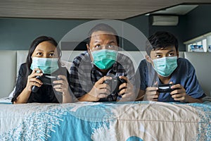 Father and his children playing video game on bed