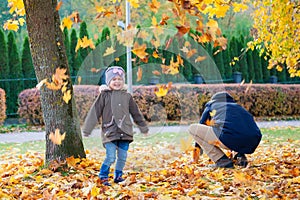 Father and his cute daughter playing with leaves
