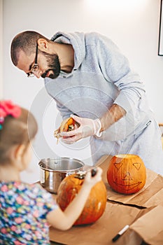Father and his daughter carving pumpkins