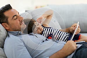 Father and his daughter enjoying free time with tablet