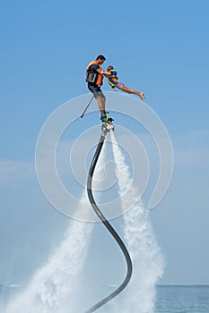 Father and his daughter posing at new flyboard at Caribbean tropical beach. Positive human emotions, feelings, joy. Funny cute chi