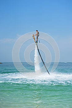 Father and his daughter posing at new flyboard at Caribbean tropical beach. Positive human emotions, feelings, joy. Funny cute chi