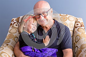 Father and his daughter sitting in armchair