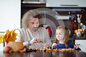 Father and his kid making chestnuts creatures